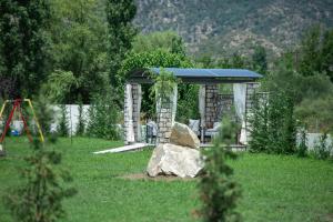 a gazebo in a yard with a rock at A Ponte Studios & Apartments in Sykia Chalkidikis