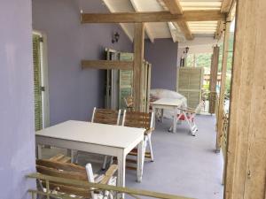 a dining room with a table and chairs on a porch at Trocolo Apartments in Sivota