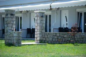a stone retaining wall in front of a house at A Ponte Studios & Apartments in Sykia Chalkidikis