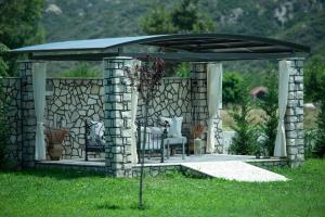 a gazebo with a table and chairs under it at A Ponte Studios & Apartments in Sykia Chalkidikis
