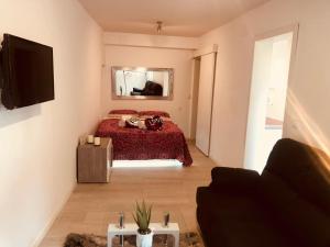 1 dormitorio con cama roja y sofá en Apartment in Sol, en Madrid