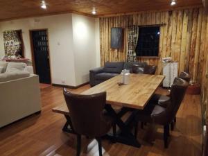 a living room with a wooden table and chairs at Ngomongo in Nanyuki