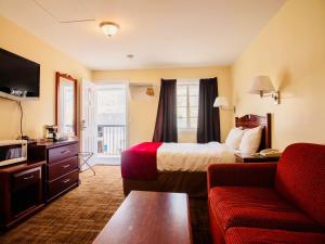 pokój hotelowy z łóżkiem i kanapą w obiekcie Kings Motor Inn w mieście Kamloops