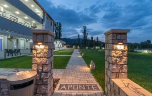 a brick pathway in front of a building with lights at A Ponte Studios & Apartments in Sykia Chalkidikis