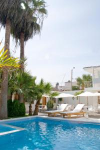 a swimming pool with lounge chairs and palm trees at Caballito de Totora in Huanchaco