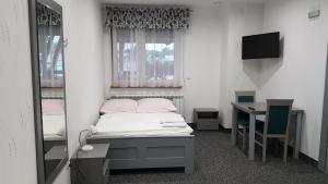 a bedroom with a bed and a desk and a television at Kryształowa Józefów in Józefów