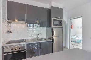 kuchnia z lodówką ze stali nierdzewnej i zlewozmywakiem w obiekcie Los Cristianos Heated Pool Sea View Diamantes WIFI w mieście Los Cristianos