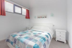 biała sypialnia z łóżkiem i dwoma oknami w obiekcie Los Cristianos Heated Pool Sea View Diamantes WIFI w mieście Los Cristianos
