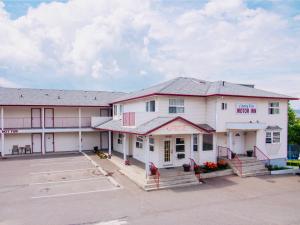 een groot wit gebouw met een parkeerplaats bij Country View Motor Inn in Kamloops