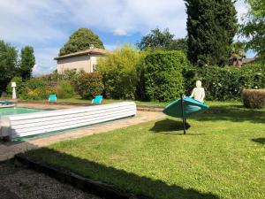 a statue of a person in a boat in a yard at Appartement piscine in Tonneins