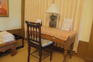 a wooden desk with a lamp and a chair at Khum Khun Wang Resort in Mae Wang