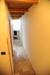 a hallway with a white wall and a room at Palazzo Grigio in Bari