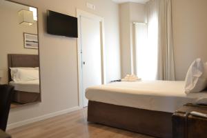 バーリにあるGatto Bianco Le Terrazzeのベッド2台と鏡が備わるホテルルームです。