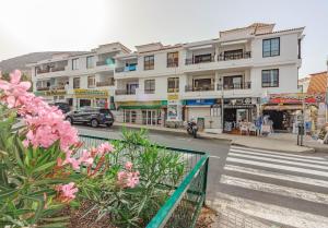 budynek na ulicy z różowymi kwiatami w obiekcie Los Cristianos Heated Pool Sea View Diamantes WIFI w mieście Los Cristianos