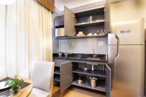 a small kitchen with a refrigerator and a table at Hotel Residences Studio Pinheiros in Sao Paulo