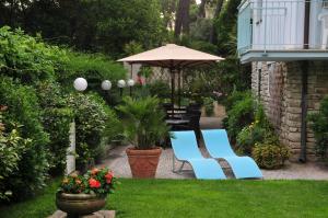 a patio with two blue chairs and an umbrella at Hotel Riviera Blu in Tirrenia