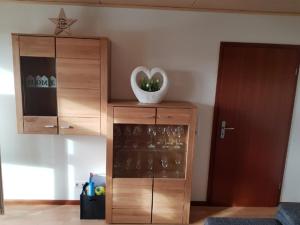 ein Holzschrank mit einer Schale mit Weingläsern in der Unterkunft Ferienwohnung Witt in Rheinhausen