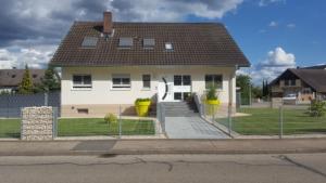 a white house with a brown roof at Ferienwohnung Witt in Rheinhausen