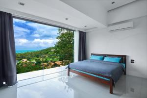 sypialnia z łóżkiem i dużym oknem w obiekcie villa Siam View Samui w mieście Ban Bang Po