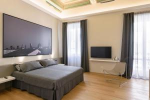 モンテヴァルキにあるPalazzo Vasarri - Luxury design suitesのベッドルーム(ベッド1台、薄型テレビ付)