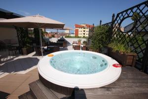 a hot tub on a deck with an umbrella at Hotel Naxos B&B in Alba Adriatica