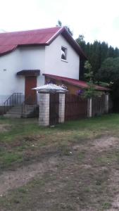 una casa blanca con una puerta y una valla en Ginto nakvynės namai en Vilna