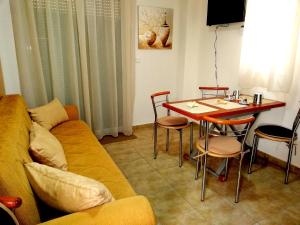 a living room with a couch and a table with chairs at Kalamata Downtown Apartment in Kalamata