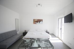 Camera bianca con letto e tavolo in vetro di Guest House Lovely Swan a Lagos