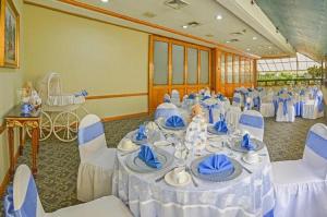 un salón de banquetes con una mesa con sillas azules y blancas en Hotel Santander Plaza, en Guatemala