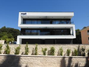 een groot wit gebouw met bomen ervoor bij Luxury Apartments Magali 3 in Rovinj