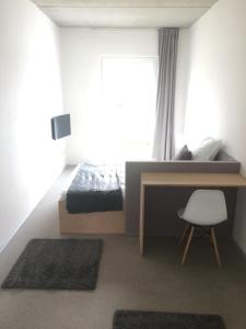 a bedroom with a bed and a desk and a window at Designer Studio Geestland in Langen