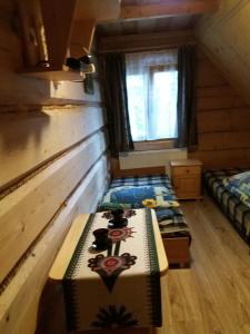 ザコパネにあるZakopane góralski domekのログキャビン内のベッド2台が備わる部屋です。