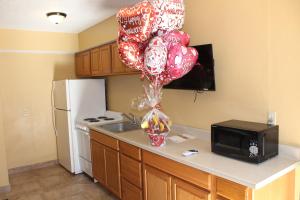 W kuchni znajduje się blat z czerwonymi i białymi balonami oraz kuchenka mikrofalowa. w obiekcie The Executive Inn & Suites w mieście Amarillo