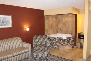 アマリロにあるThe Executive Inn & Suitesのリビングルーム(バスタブ、ソファ、椅子付)