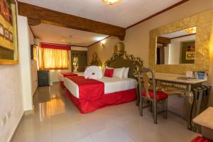 Habitación de hotel con cama grande y escritorio. en Hotel Las Golondrinas, en Playa del Carmen
