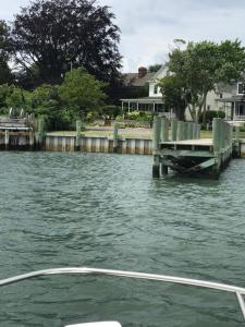 um barco em uma massa de água com uma doca em The Stirling House Waterfront Inn Greenport em Greenport