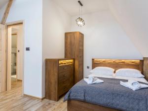 1 dormitorio con cama, tocador y espejo en House Apart 132, en Poronin