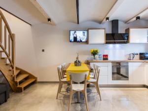 cocina y comedor con mesa amarilla y sillas en House Apart 132, en Poronin
