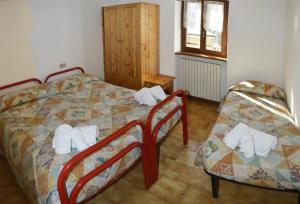 a bedroom with a bed and two chairs at Valdigiust in Campodolcino