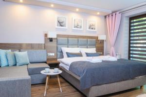 a bedroom with a bed and a couch at BALTIC PLAŻA przy plaży in Krynica Morska