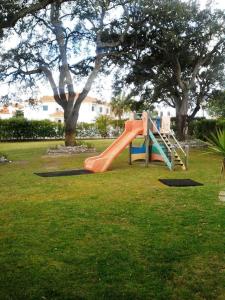 einen Spielplatz mit einer orangenen Rutsche in einem Park in der Unterkunft Hotel ibis Setubal in Setúbal