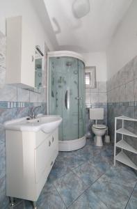 ein Bad mit einer Dusche, einem Waschbecken und einem WC in der Unterkunft Apartman Angelina in Supetar