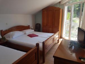 a bedroom with two twin beds and a television at Villa Luka in Brela