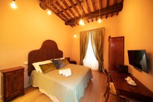 1 dormitorio con 1 cama grande y TV en Le Camere Di Boccanegra en Sarzana