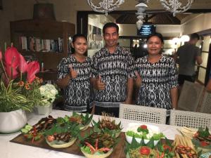 a group of three men standing next to a table with food at Villa Elleo in Seminyak +64 photos