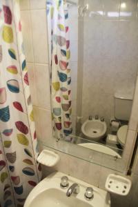 Un baño con lavabo, inodoro y espejo. en Depto En El Centro - Dean Funes, en Córdoba 8 fotos más