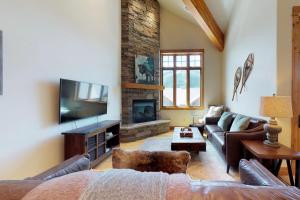 a living room with a couch and a fireplace at Alpenglow 34C in Big Sky
