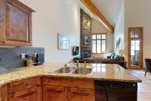 a kitchen with a sink and a living room at Alpenglow 34C in Big Sky