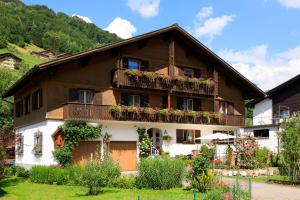 ein Haus mit Blumenkästen auf den Balkonen in der Unterkunft Apartment Am Bach in Mellau