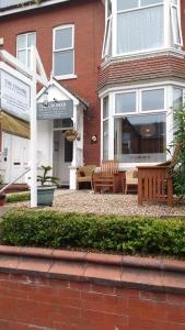 a house with two benches in front of a building at Cromer Guest House in Bridlington